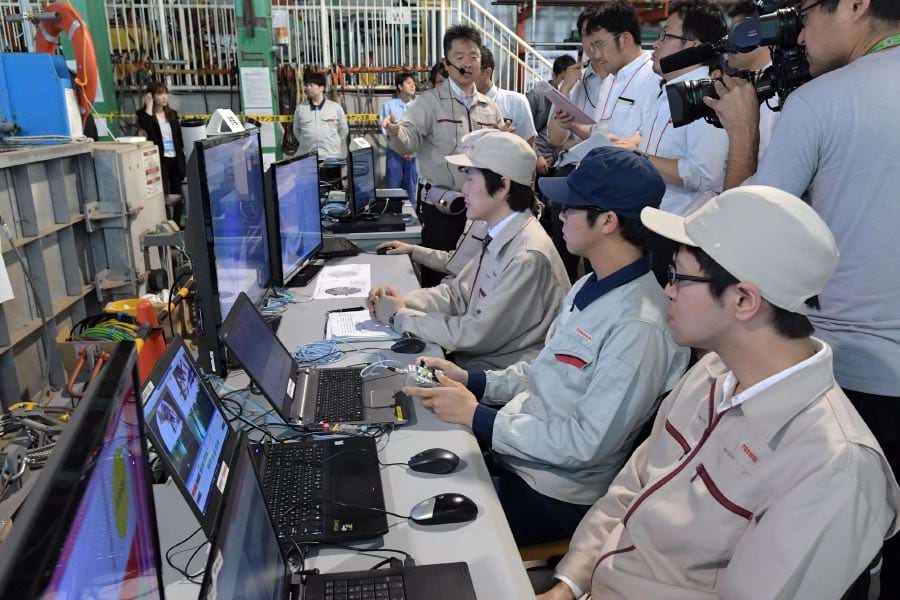 ロボットから送信される映像を見ながら操作する職員。圧力容器底部の構造物の損傷状況を確認し、さらに下へと潜水できるルートがあればペデスタル底部の状況も調べる。