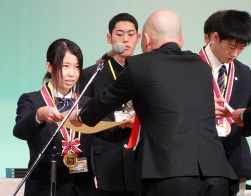 電気工事部門で優勝し、表彰状を受け取る門田さん（左）