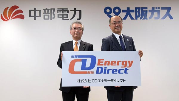会見で新会社名が書かれたボードを手にする中部電力の勝野社長（左）と大阪ガスの本荘社長（２７日、東京・丸の内）