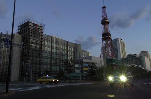 未明に発生した地震で停電した札幌市内。信号やビルの灯りは消え、自動車のヘッドライトだけが光っている（６日朝）