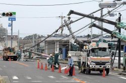 田尻町で倒壊した電柱を撤去する作業員
