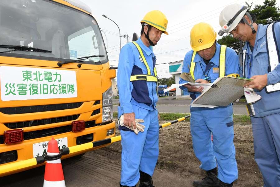 応急送電作業を控え北海道電力社員(右)と打ち合わせ中の東北電力関係者(7日、北海道厚真町)