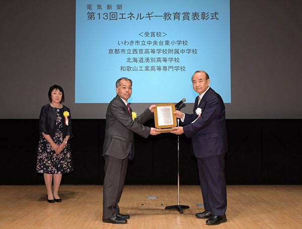 最優秀賞を受賞した中川西京高等学校附属中学校副校長に表彰状を渡す福田会長（右）