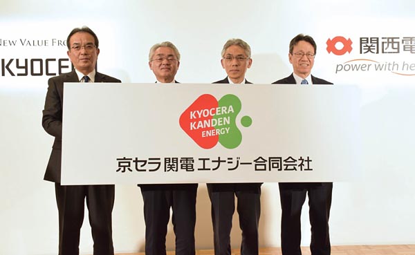 新会社のロゴを掲げる京セラの谷本社長（左）と関西電力の岩根社長（右）