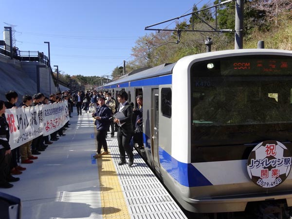 一番列車からホームに降り立つ利用者を横断幕が出迎えた