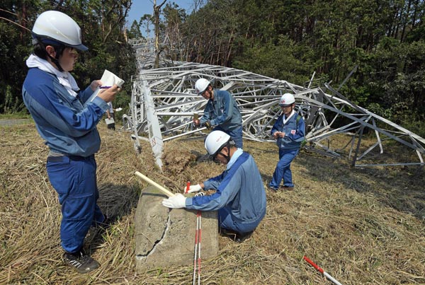 倒れた鉄塔の基礎部分を調査する東電ＰＧ社員（１０日、千葉県市原市）