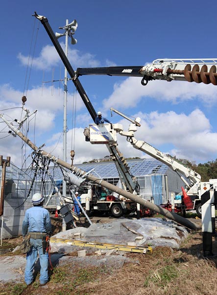 台風15号で倒壊した電柱をクレーンで起こそうとする作業班(千葉県館山市)