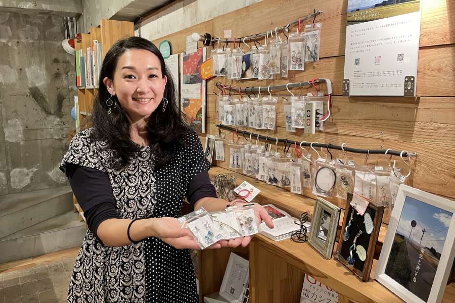 ブックカフェの壁に林さんのアクセサリーが飾ってある。説明を受けないと電線素材だと分からないほど