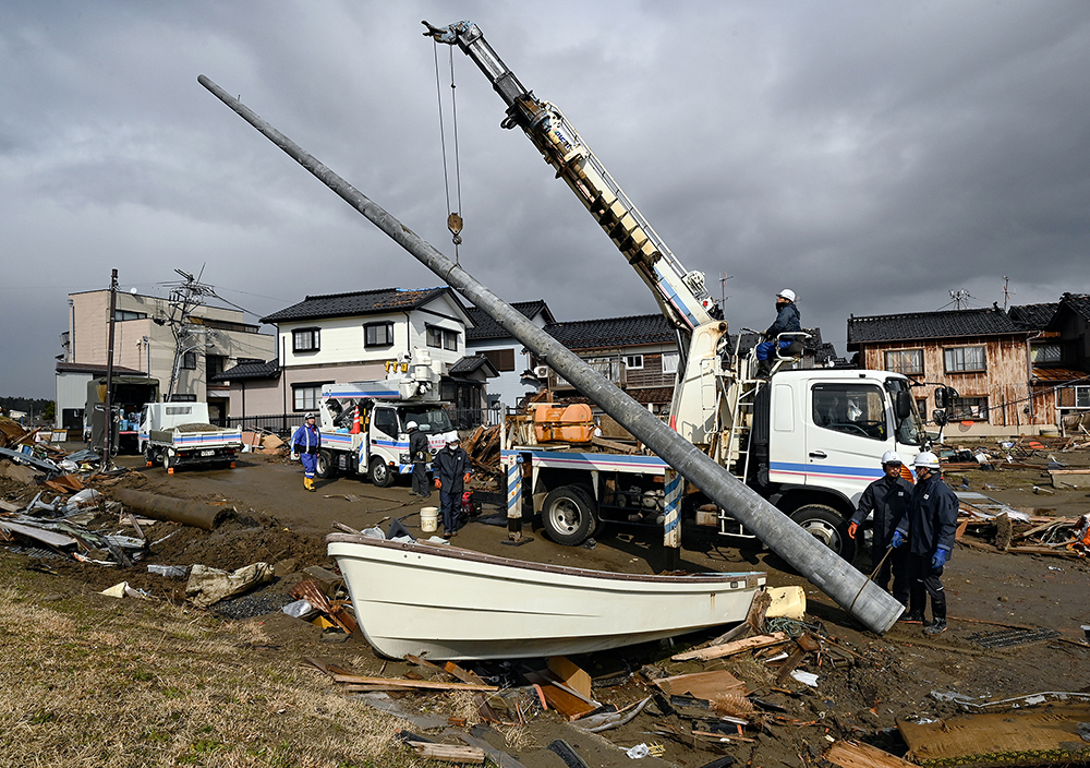 折損した電柱を引き抜き新たな電柱を建てる。北陸電力送配電と北陸電気工事の富山エリアの協力会社が作業にあたっている