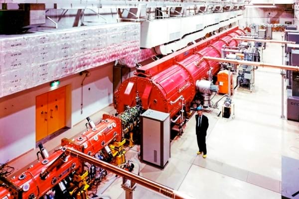 1987（昭和62）年に建設が始まった重粒子線治療装置（HIMAC）。2024年（令和6）には電気学会の顕彰「でんきの礎」に選ばれた。25年3月末までの登録患者数は1万6000例を超えたほか、基礎科学分野の研究や重粒子治療に関連した臨床研究にも生かされている