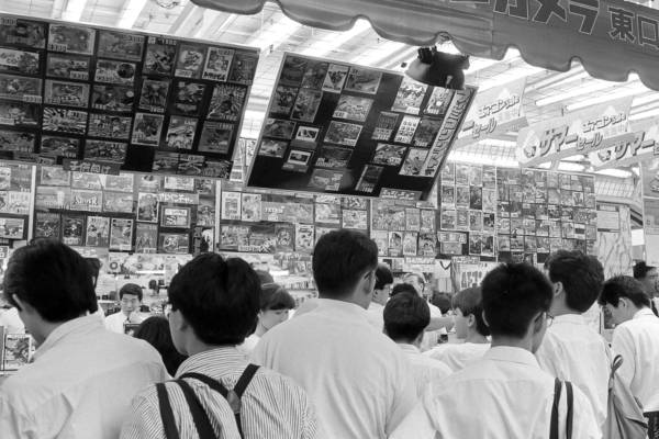 インベーダーゲームやファミコン（ファミリーコンピュータ）など、昭和時代に生まれたゲームは度々、社会現象といわれる風景を生んだ。写真はファミコンソフトが並べられた家電量販店の店頭に集まった多くの人々（東京・新宿）